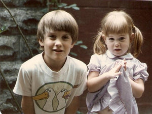 Boy and girl toddlers looking at camera.  