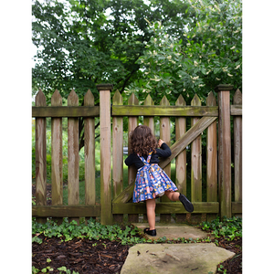 Toddler in pinafore dress, back view