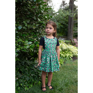 Toddler modeling girls pinafore dress in herbs