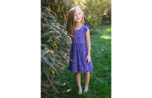 Girl modeling purple ruffle sleeve twirly dress in robots: STEM clothing for girls