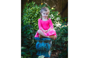 Girl wearing twirly dress in hot pink velvet