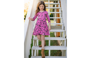 Girl modeling hot pink dinosaur twirly dress: stem clothing for girls