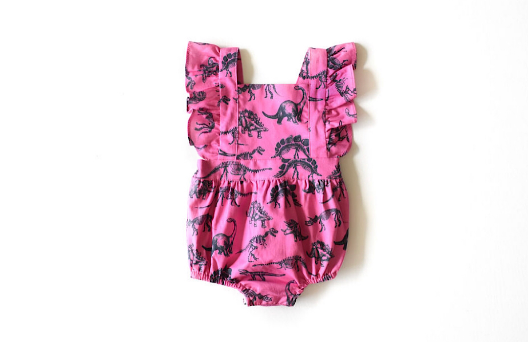 Baby bubble romper in hot pink dinosaur print. STEM clothing for girls!